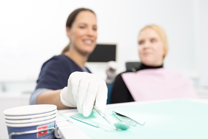 Eine Zahnärztin prüft die Zähne einer jungen Dame.